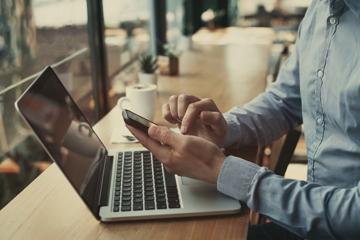 social media, closeup of hands holding smartphone in cafe using microsoft teams as a phone system